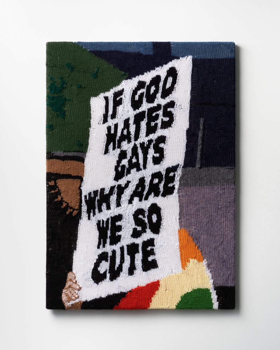 A knitted protest sign that says, "IF GOD HATES GAYS WHY ARE WE SO CUTE".