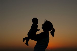 A women's silhouette holds a baby