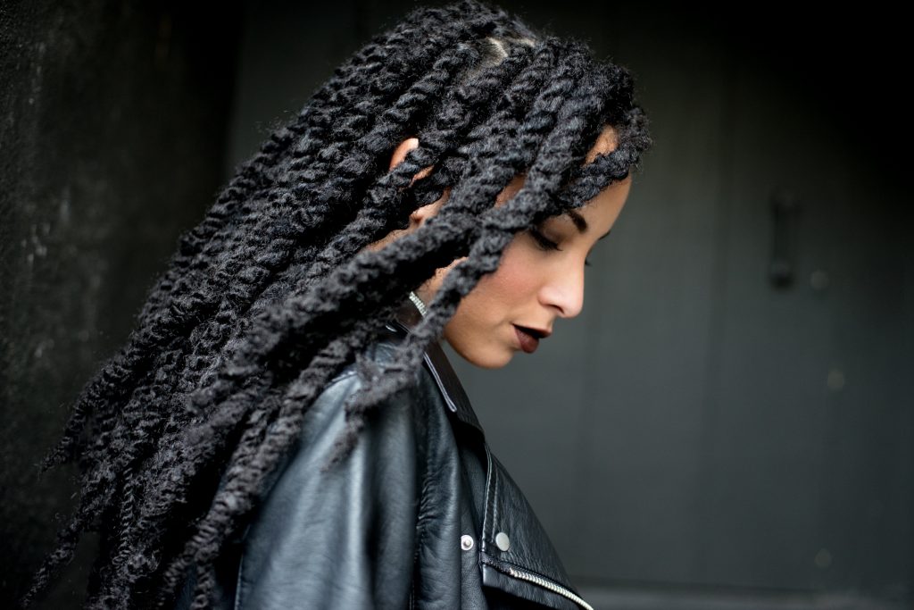 a black woman flips her hair dreads