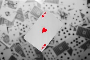 An ace of hearts playing card in colour on top of a pile of cards