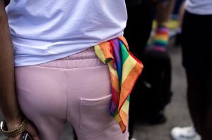 A rainbow flag handkerchief hangs out the back of a person's pants.