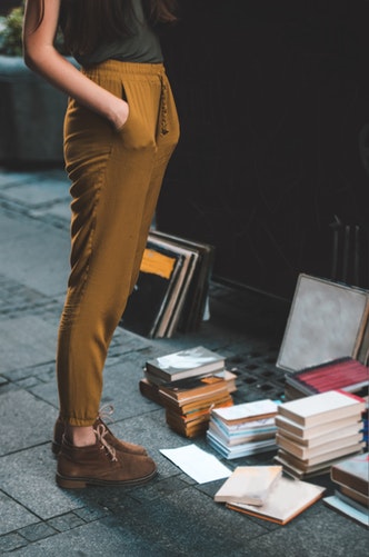 Person standing in front of piles of books