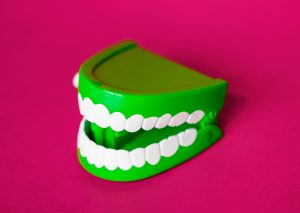 Pink background with a green windup mouth toy