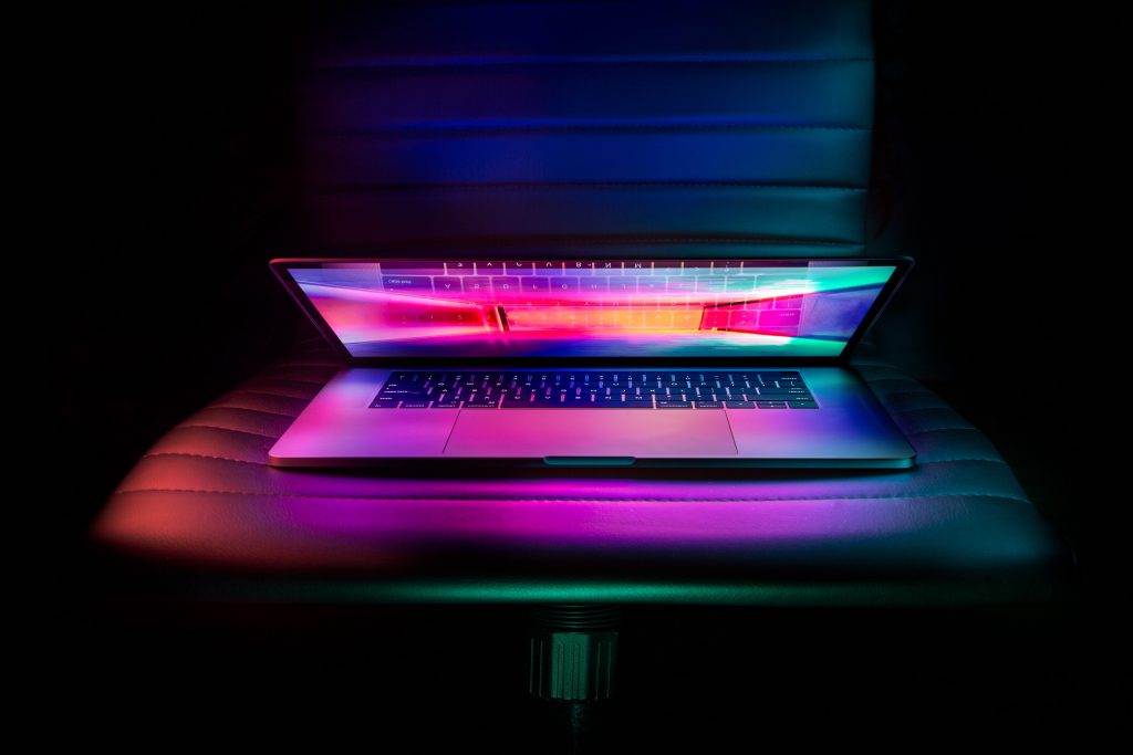 Partially closed laptop with colourful light showing