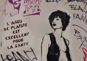 Street art that depicts a person wearing an open shirt, and with French words