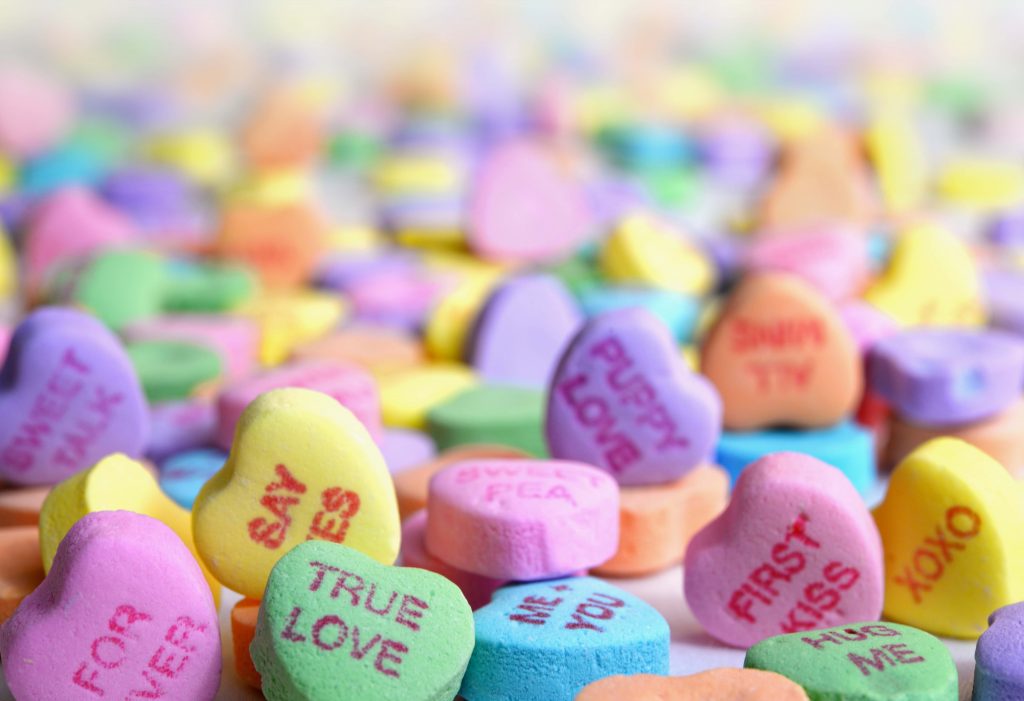 candy love hearts in different colours read "say yes", "true love" "puppy love", "first kiss" "me and you", "forever"