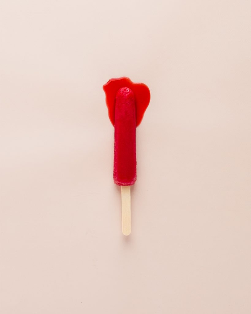A red ice block / popsicle melting in the heat