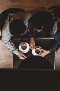 Two people having coffee and hugging, shown from above
