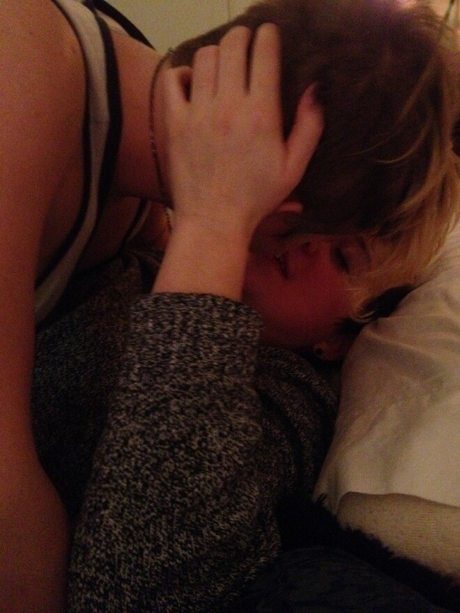 Two people kissing in bed