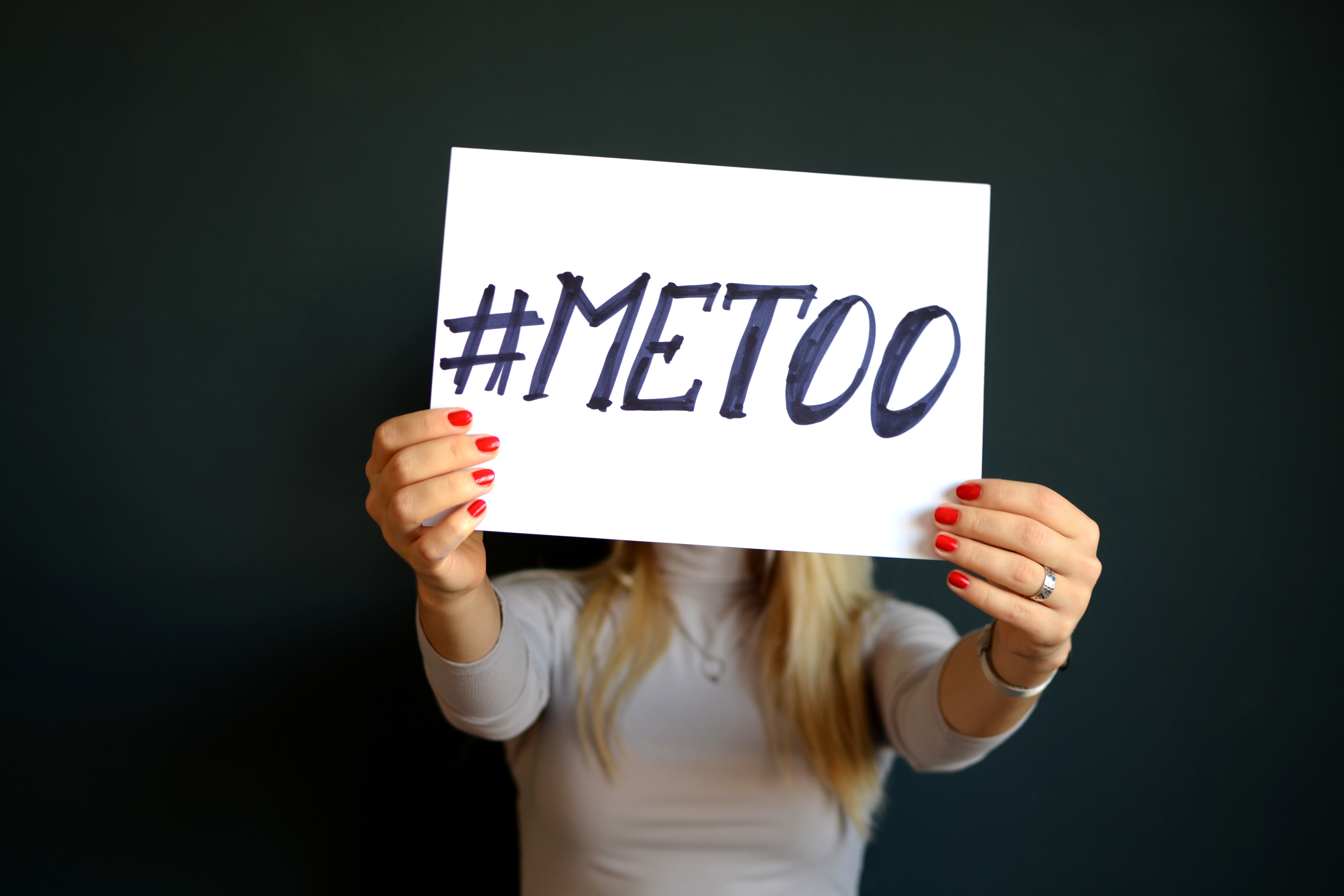 Person holding a sign that says #MeToo