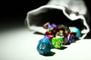 Colourful dice spill out of a bag