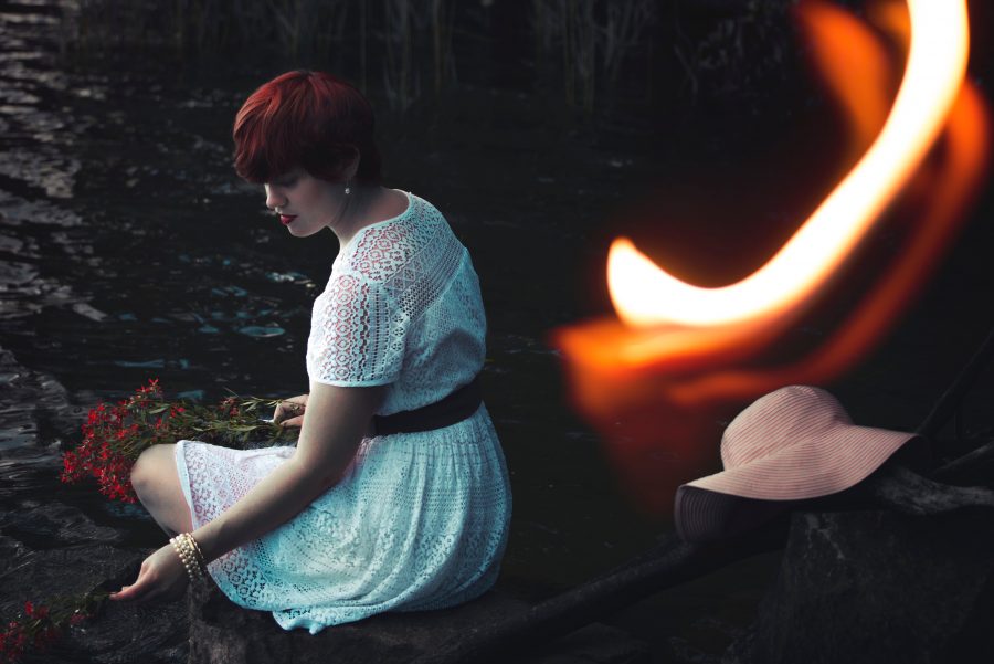 Person wearing a dress sitting in front of a fire