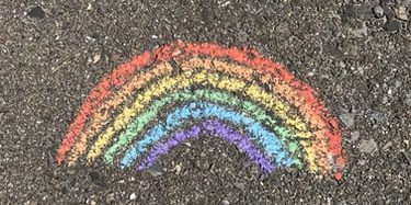 Rainbow drawn on asphalt in chalk