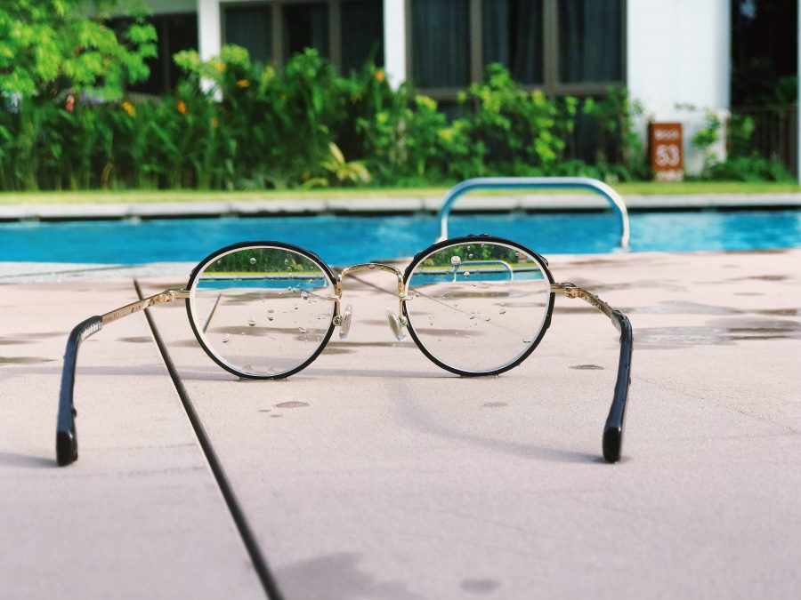 Spectacles on the ground in front of a swimming pool