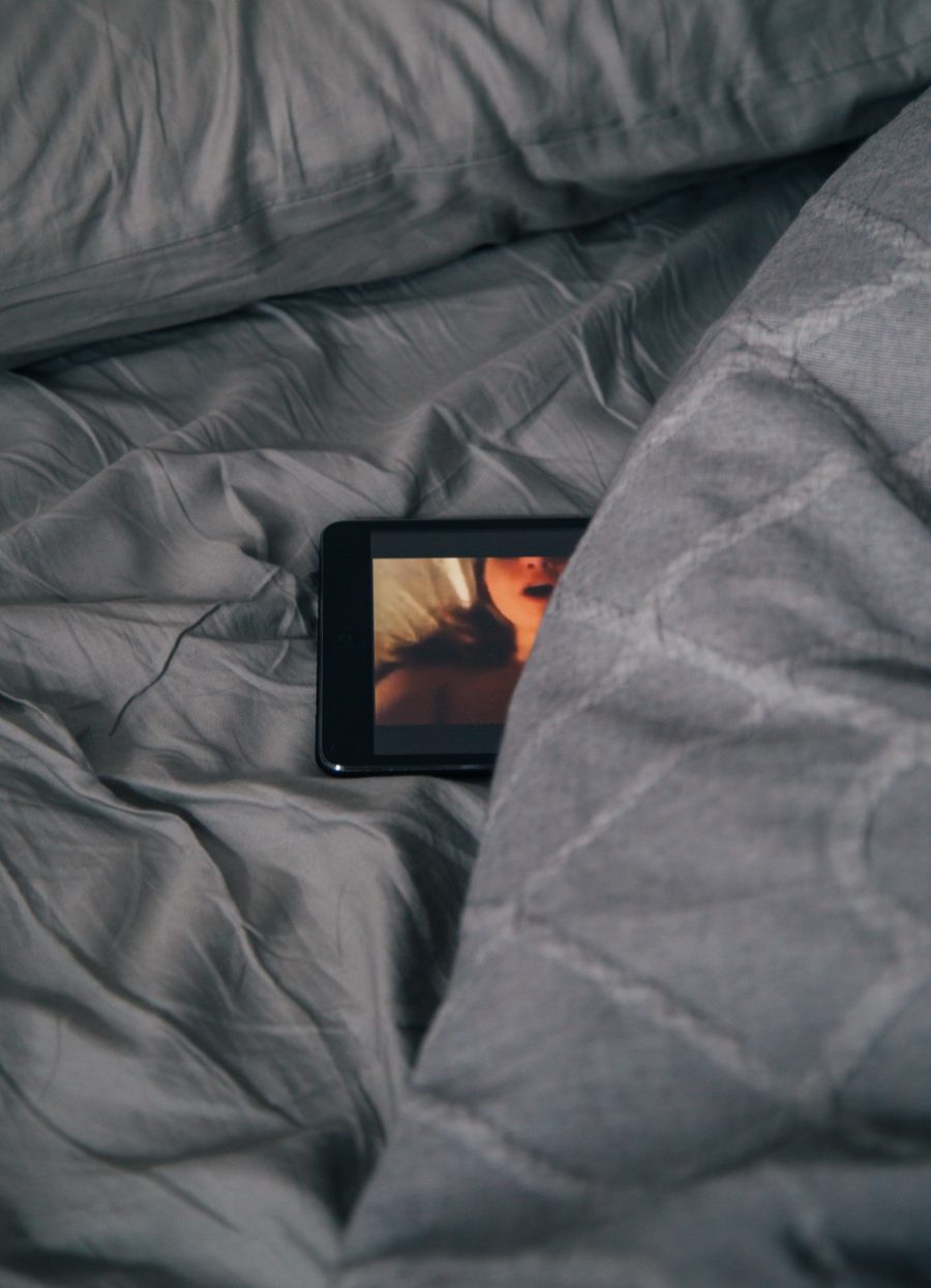 A mobile phone on a bed, showing a picture of a face