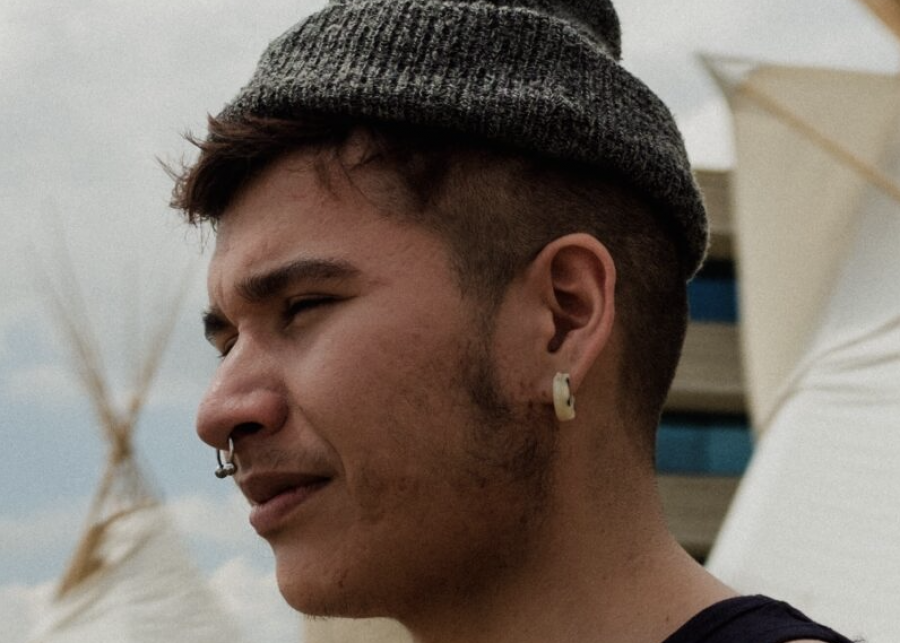A close up of author Billy-Ray Belcourt wearing a grey beanie