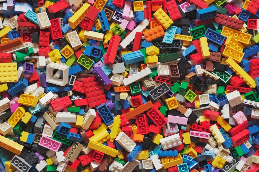 A close up of a pile of brightly coloured plastic building blocks of various shapes and sizes