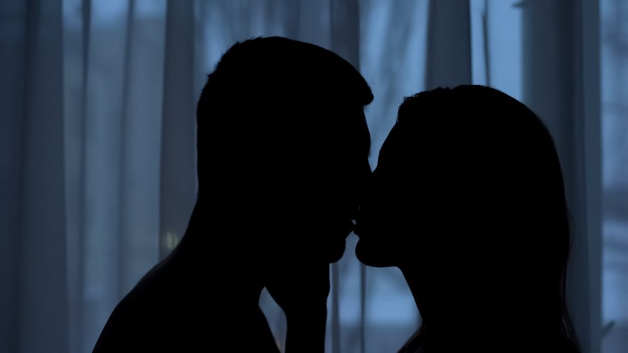 Silhouettes kissing in the dark