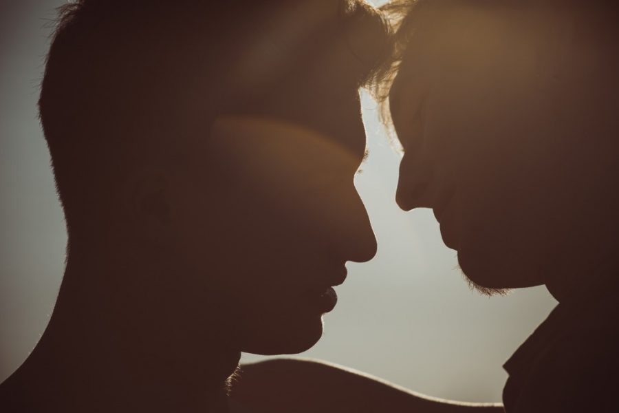 The silhouettes of two people are seen quite close, as though they're about to kiss.