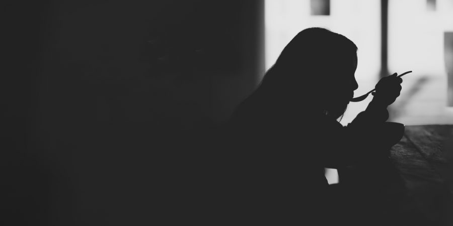 A silhouette of a person eating.
