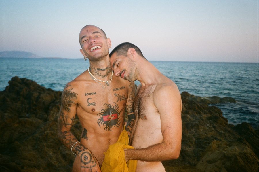 Two people cuddling and smiling on the beach.