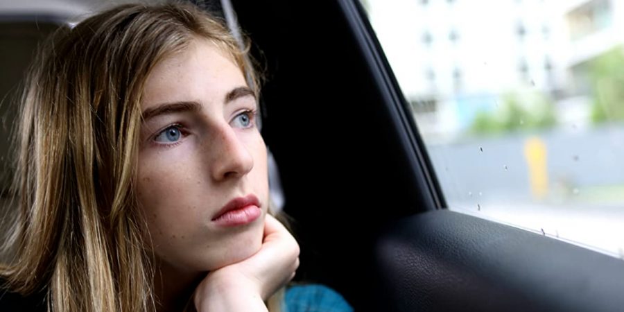 A picture of Georgie Stone staring out a car window.