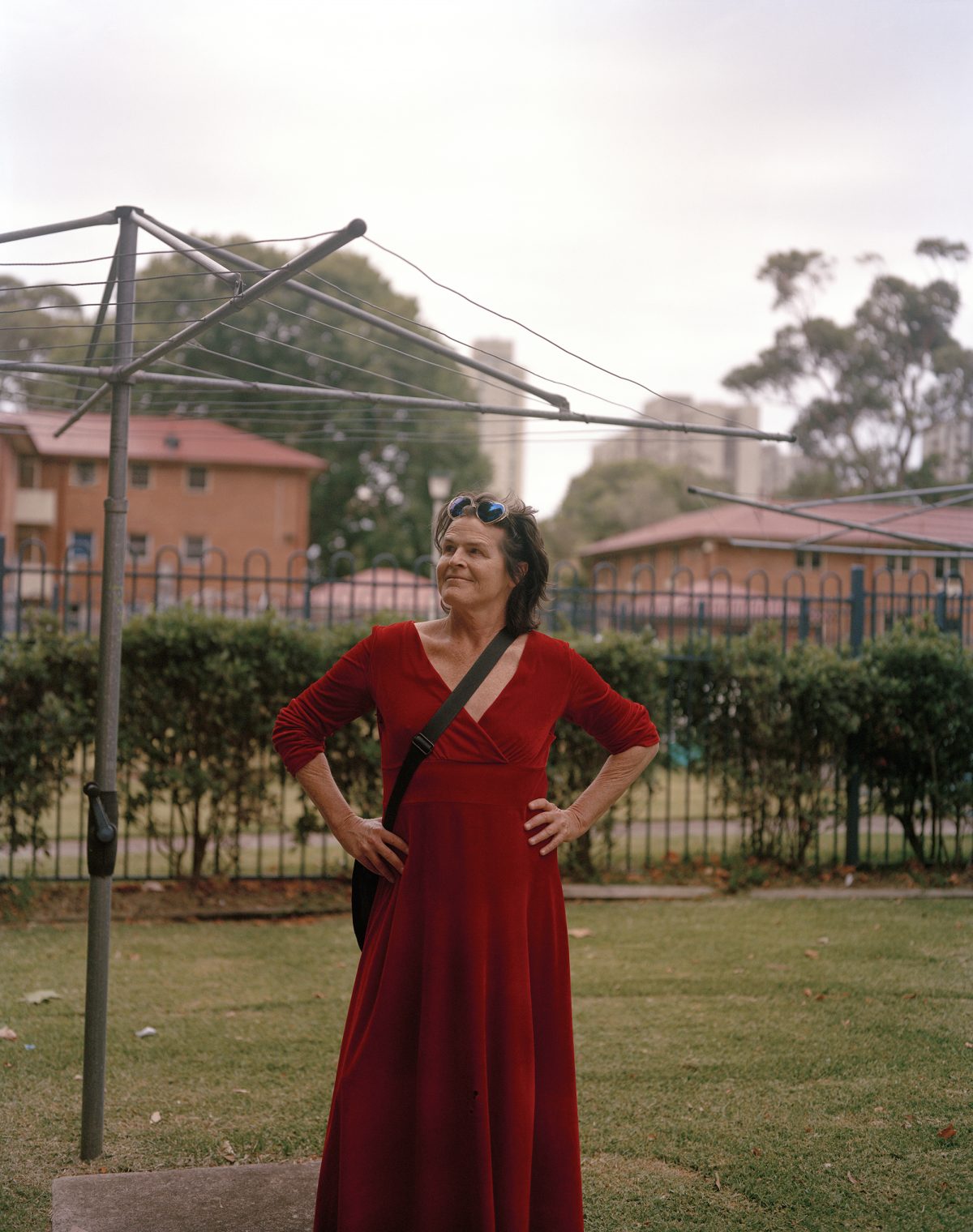 Norrie standing in a red dress near a hills hoist clothesline.