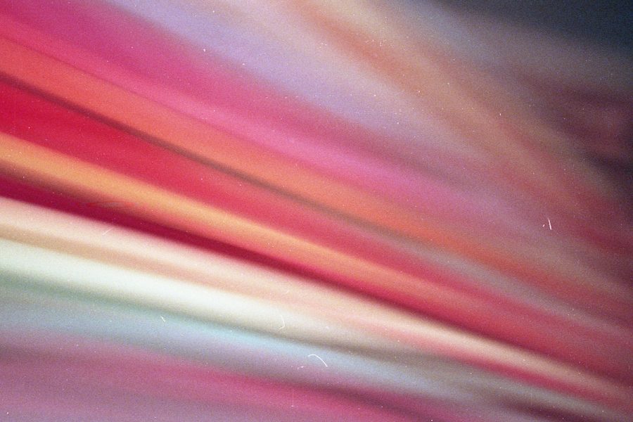 An abstract image featuring blurred colours of reds, pinks and oranges.