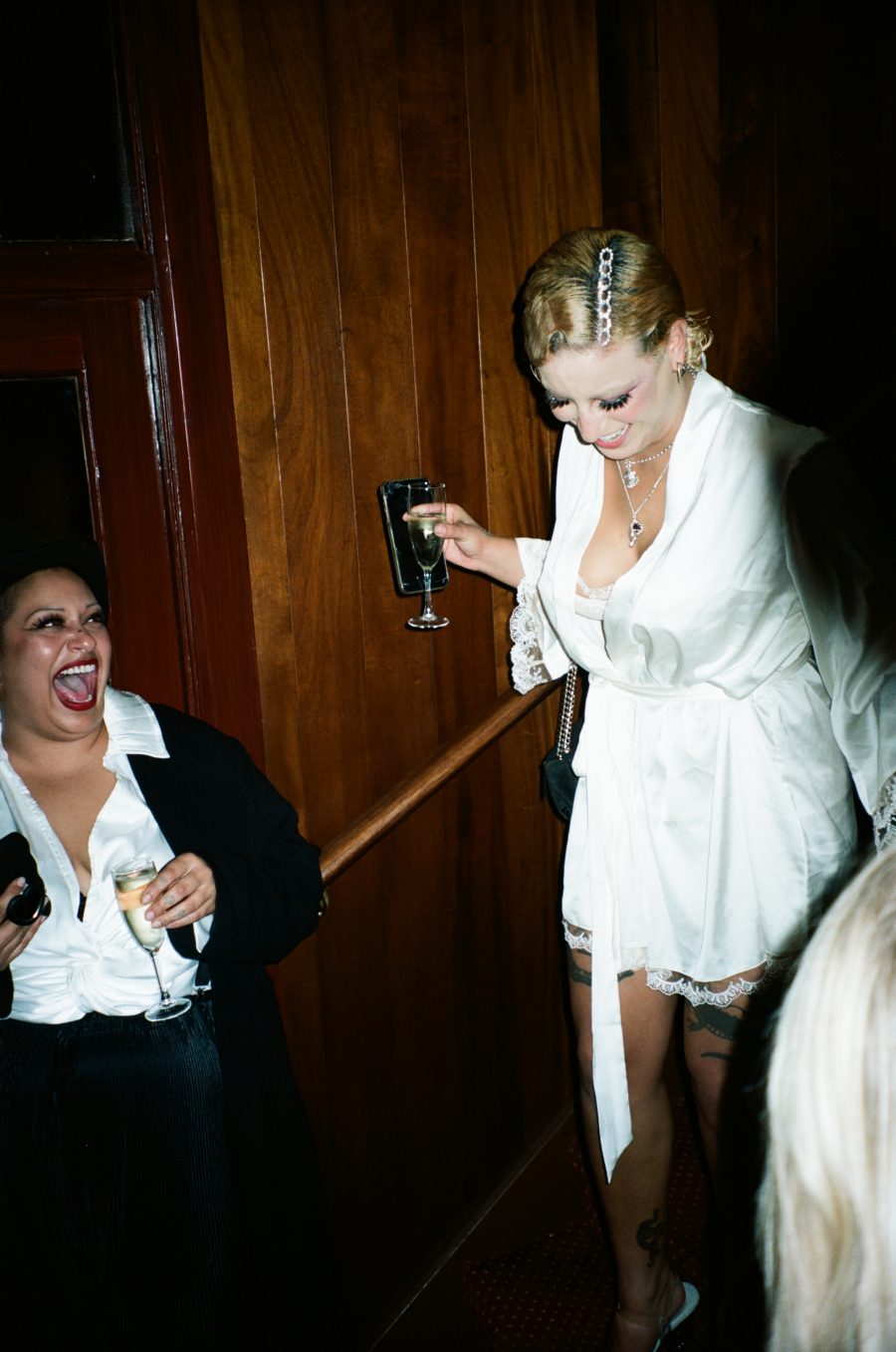 Two people laughing and having fun at a queer wedding.