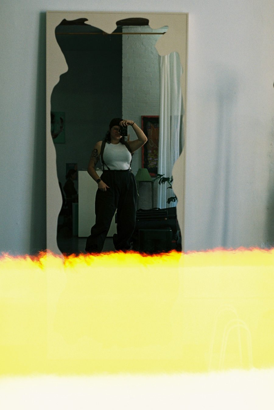 Jacinta Oaten taking a mirror selfie with their camera.