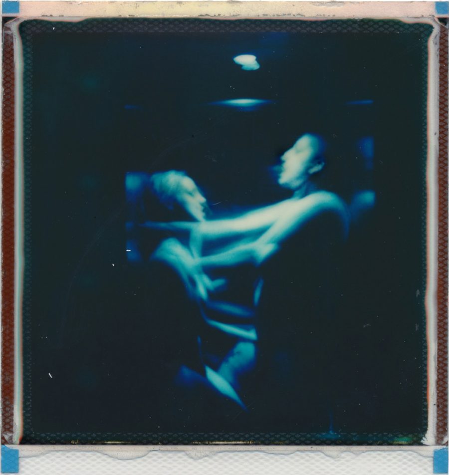 A blurred polaroid of two people having sex.
