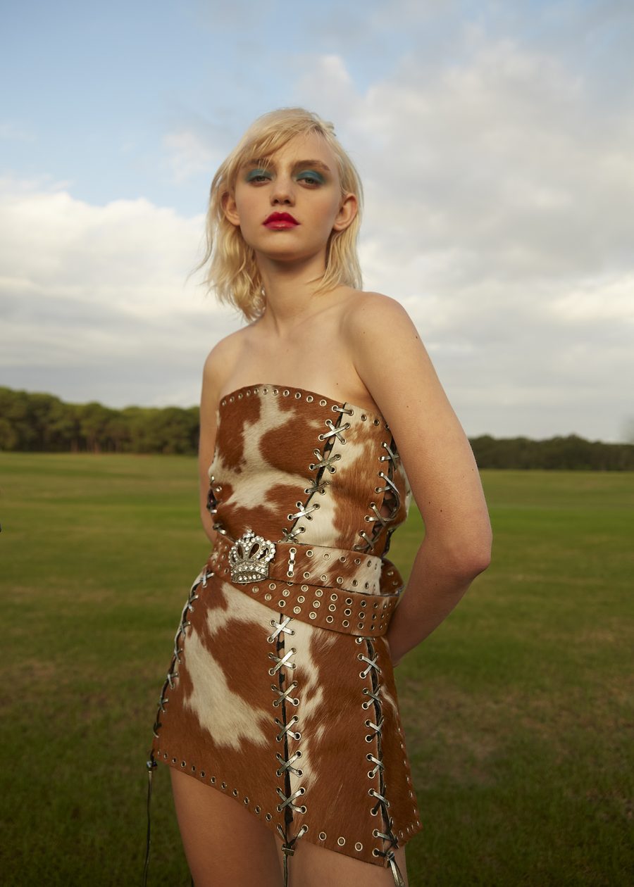 A person in a cow print outfit with metal studs and stitches. Taken by Lexi Laphor.