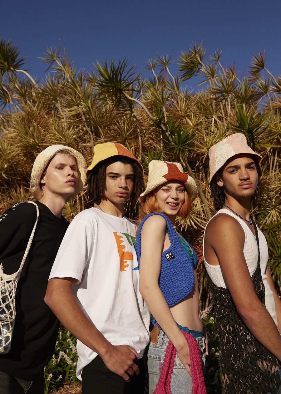 A group of four people outside wearing funky hats.