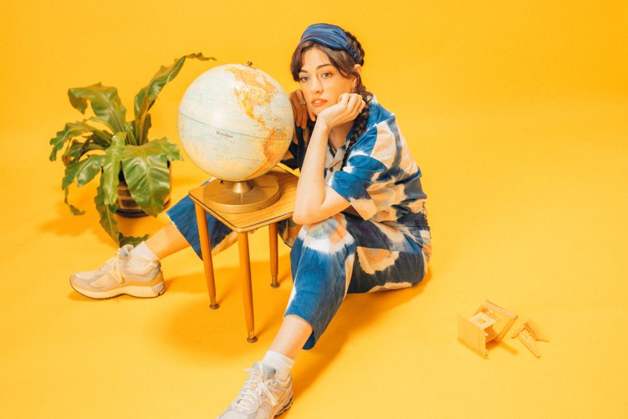 Magnets/Siobhan sitting in a yellow room in front of a globe.