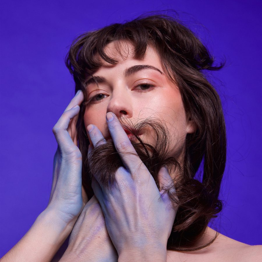 Diplacusis by Magnets. Siobhan is on the cover with three blue-stained hands resting on her chin and face.