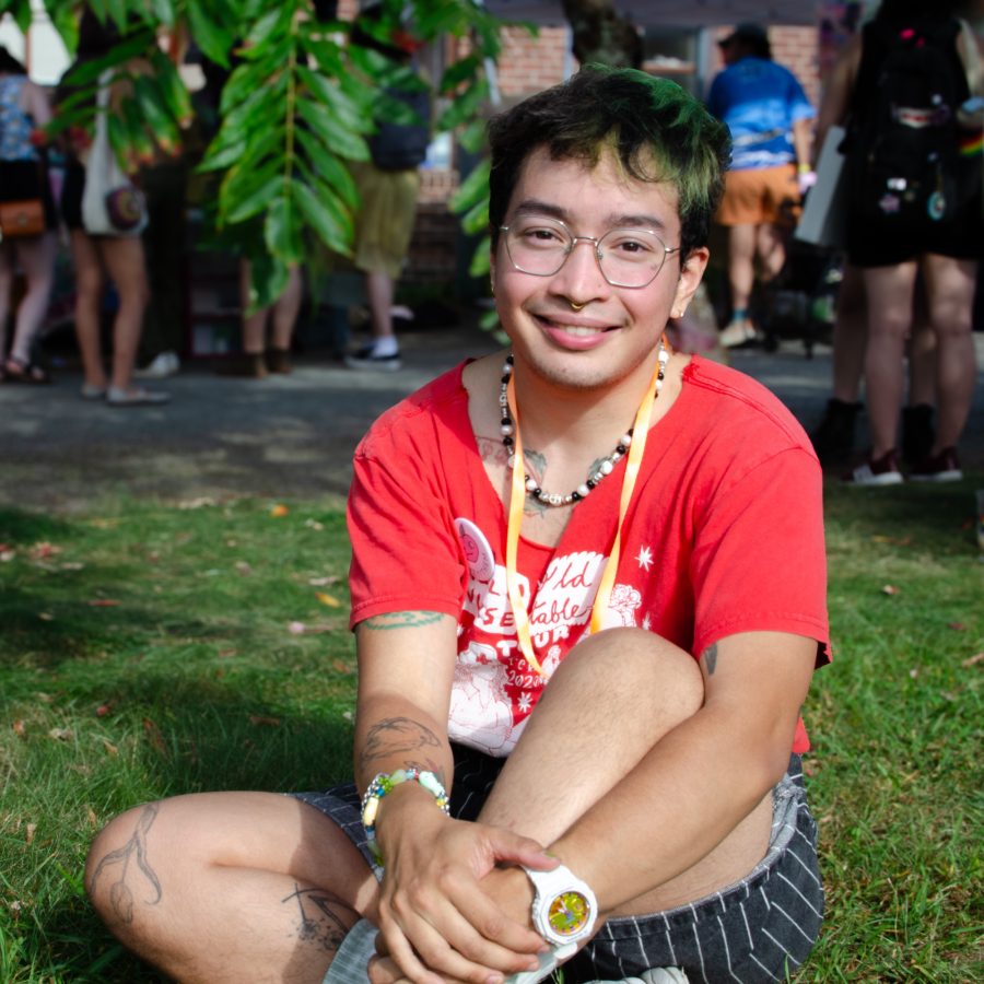 Marius Keo Marijolin sitting on the lawn at the Queer/Trans Zine Fest.