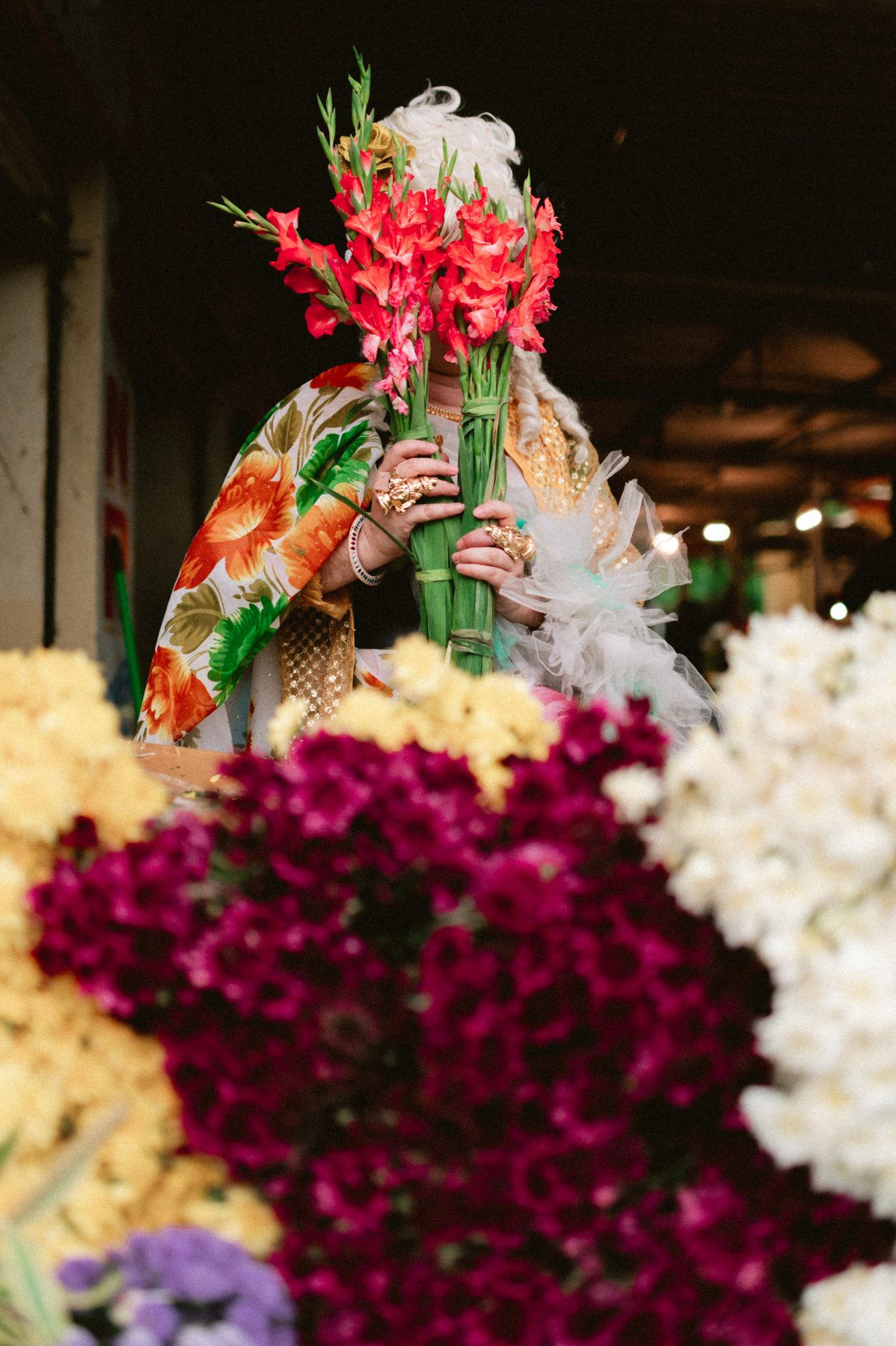 Patruni holding flowers in front of their face.