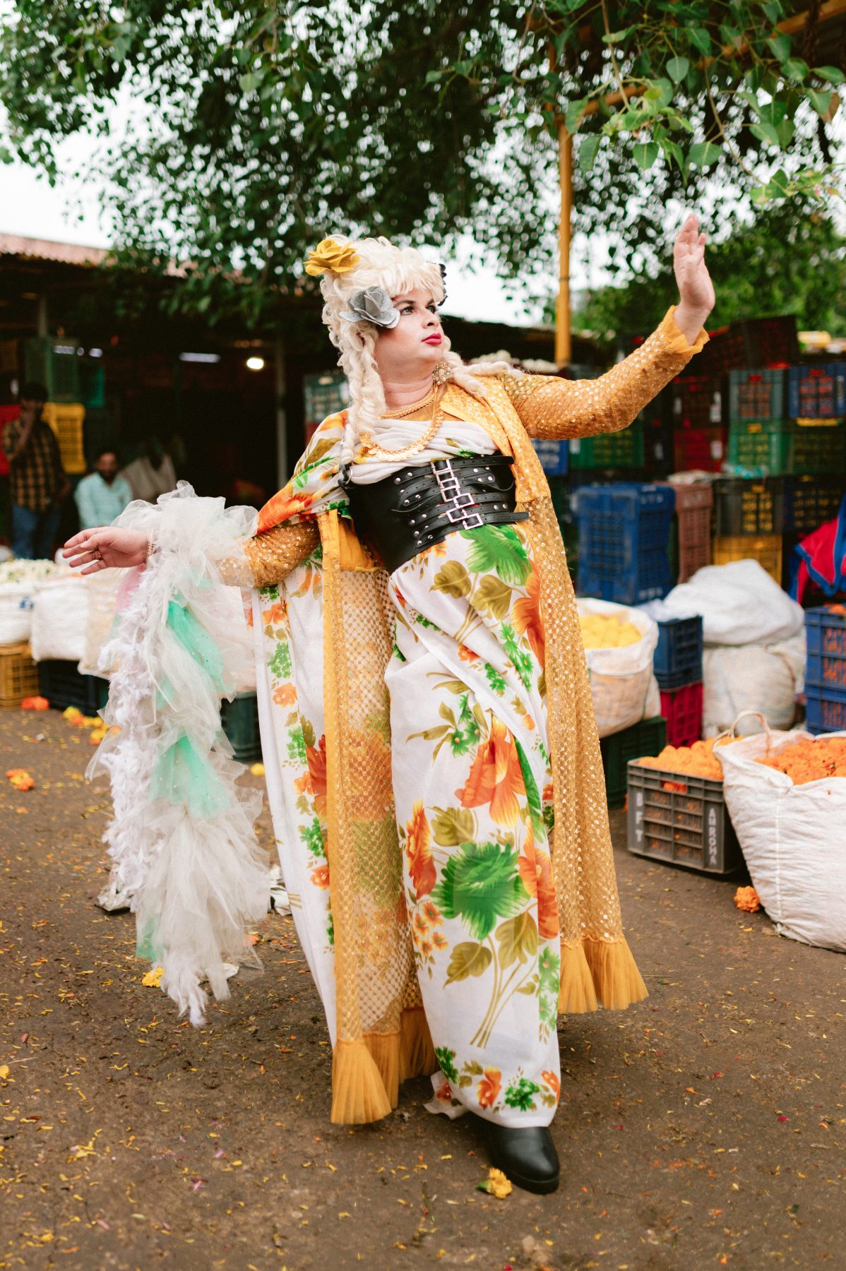 Patruni, in regal drag, dances through the flower market.