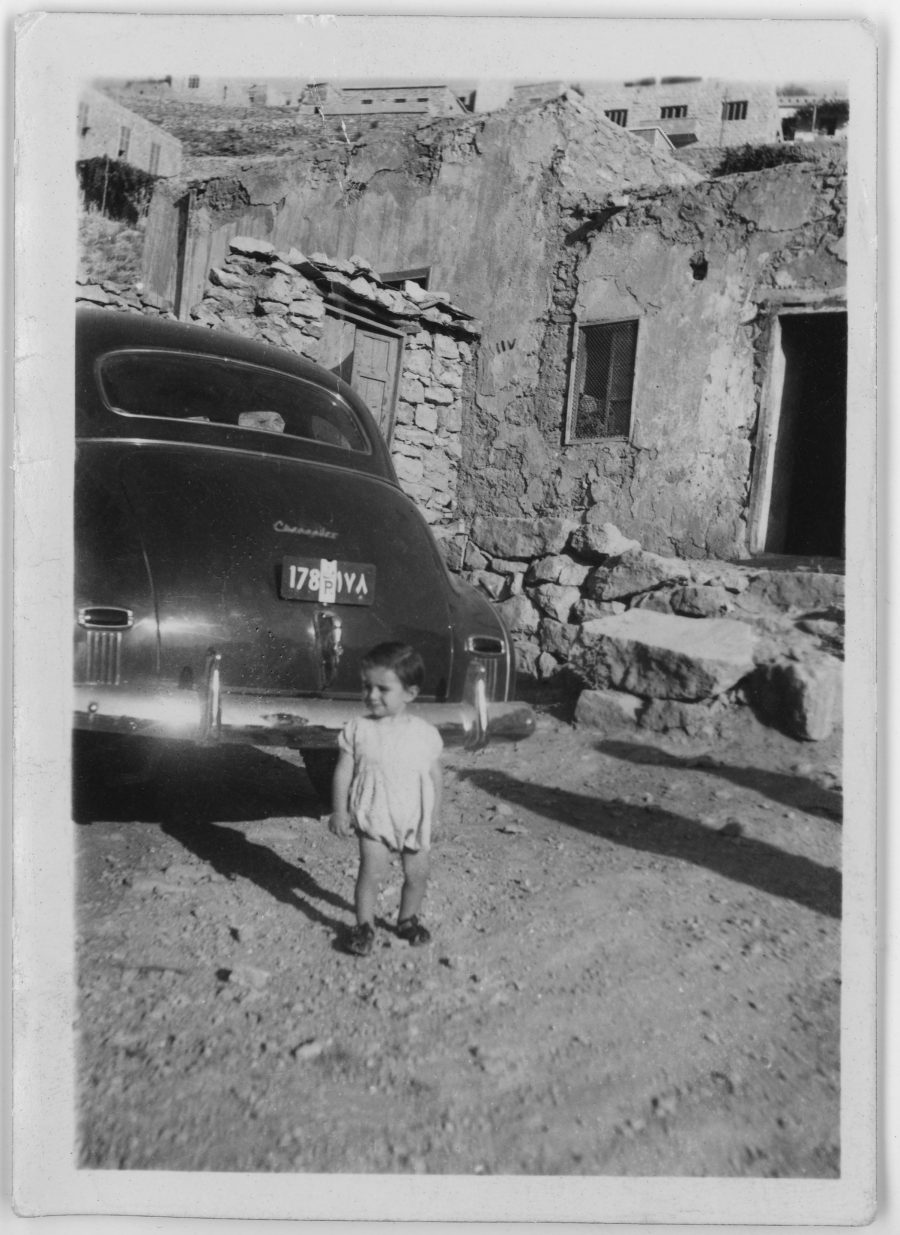 Archival photo of Joey Sahhar as a toddler standing next to a Chevrolet car.