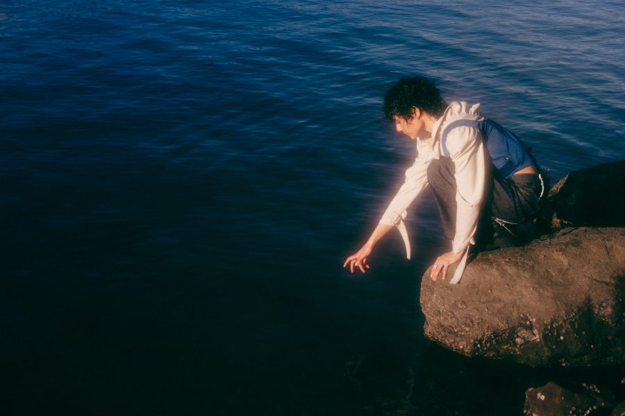 Montaigne reaching into water.