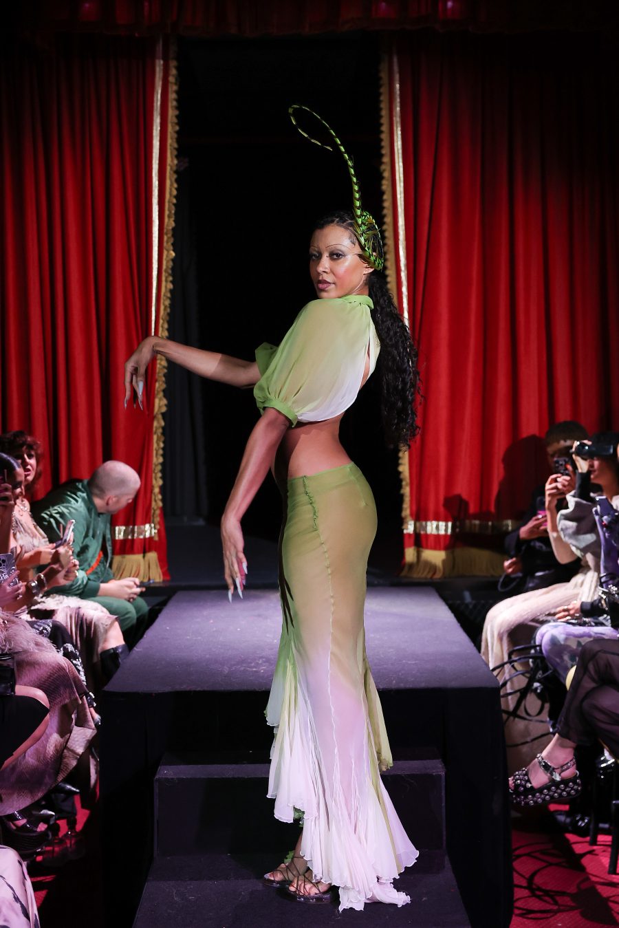 A model in an ethereal blue-green garment.