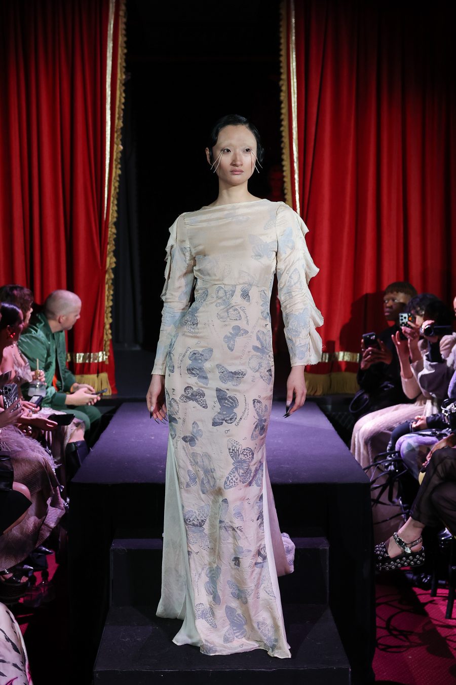 A model in a flowing dress with a butterfly print.
